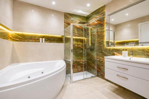 a bathroom with a tub and a shower and a sink at The Orpington View in Orpington