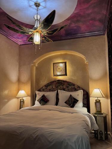 a bedroom with a large bed with a ceiling at Riad Al Ibtikar in Marrakesh