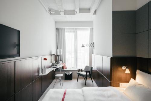 una camera da letto con un letto, una scrivania e una sedia di Ruby Lilly Hotel Munich by IHG a Monaco