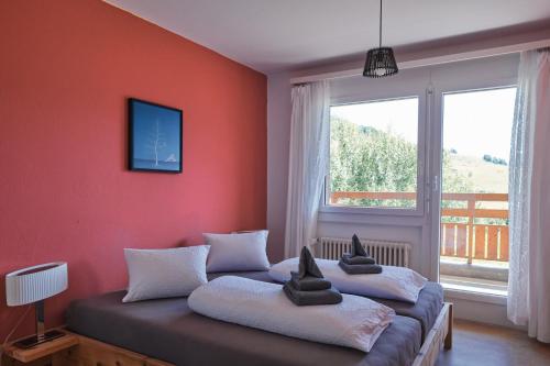 two beds in a room with a large window at Hotel Bellavista Ftan in Ftan