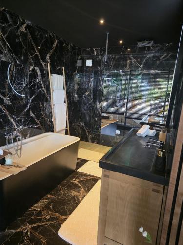 a bathroom with a bath tub and a sink at chambres d hôtes villa del sole in Puget-sur-Argens