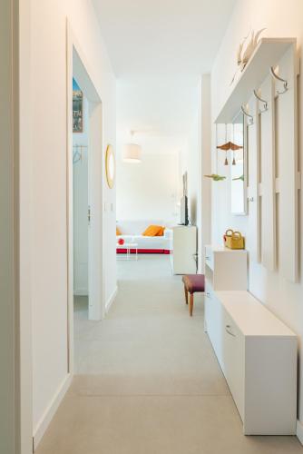 a white hallway with a room with a bed at Appartamento x 4 con wi-fi, park free, a 10 minuti dal centro di Garda in Garda