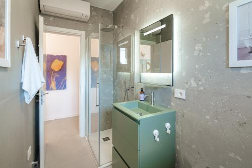 a bathroom with a green sink and a shower at Appartamento x 4 con wi-fi, park free, a 10 minuti dal centro di Garda in Garda