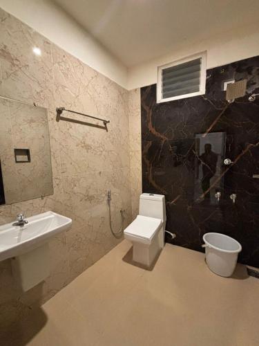 a bathroom with a toilet and a sink at Thamira Grand palace in Agastīswaram