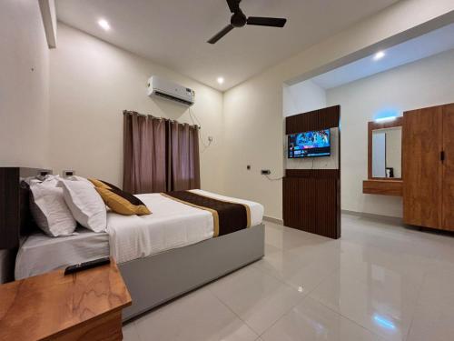 a bedroom with a bed and a flat screen tv at Thamira Grand palace in Agastīswaram