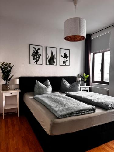 a bedroom with a bed with plants on the wall at Ferienwohnung am Auensee in Leipzig