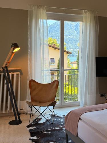 a bedroom with a chair in front of a window at Appartamento Centovalli e Verzasca in Minusio