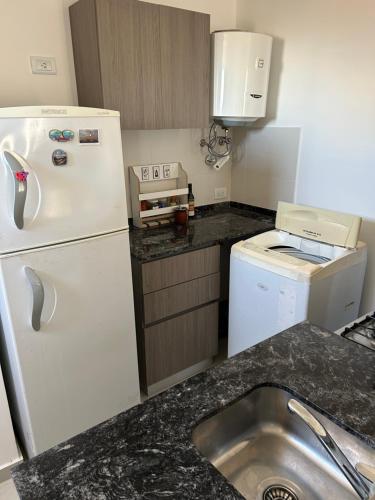 a small kitchen with a white refrigerator and a sink at Shackleton in Wilde