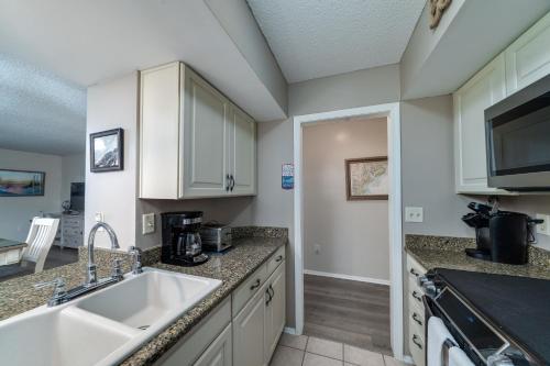 a kitchen with a sink and a microwave at 1317 Pelican Watch Villa in Seabrook Island