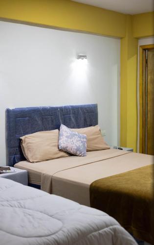 a room with two beds and a blue headboard at Hotel Ullanka in Encarnación