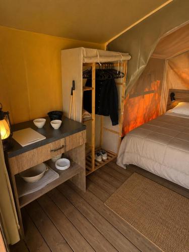a bedroom with a bed and two bowls on shelves at Camping de Retourtour in Lamastre