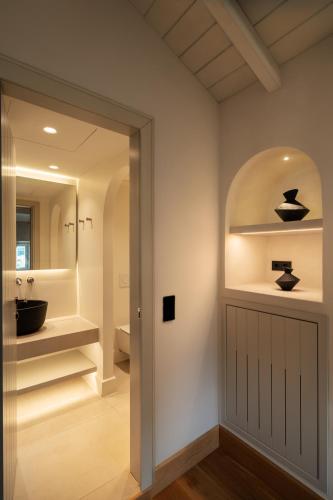 a bathroom with a black sink and a mirror at Porto Vitilo Boutique Hotel in Karavostasi