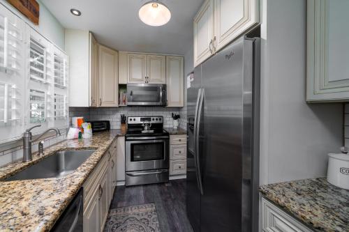 a kitchen with stainless steel appliances and white cabinets at 546 Tarpon Pond Cottage in Seabrook Island