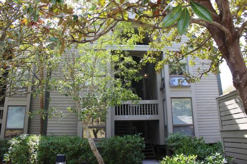 a white house with a tree in front of it at 13106 Pelican Watch Villa in Seabrook Island