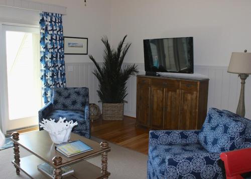 a living room with two chairs and a tv at 13106 Pelican Watch Villa in Seabrook Island