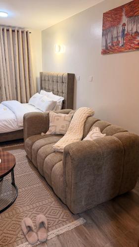 a living room with a couch and a bed at Pinnacle Homes 254 - Ruaka in Ruaka