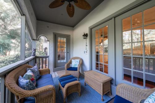a screened porch with wicker chairs and a couch at 2501 Chateau by the Green in Seabrook Island
