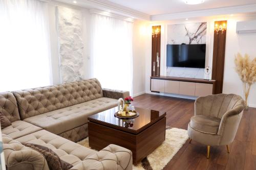a living room with a couch and a television at Apartman Lux Bileca in Bileća