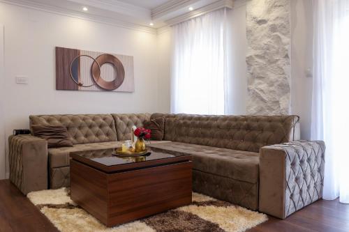 a living room with a brown couch and a coffee table at Apartman Lux Bileca in Bileća