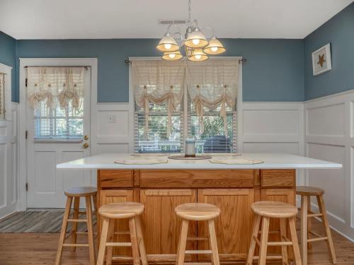 a kitchen with a large island with stools at 550 Tarpon Pond Cottage in Seabrook Island