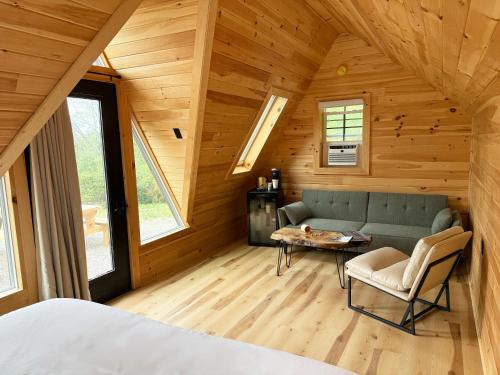 a room with a couch and a table in a cabin at Seneca Gorge Glamping in Hector