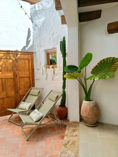 a patio with two chairs and two potted plants at Ca La Portella in Jávea
