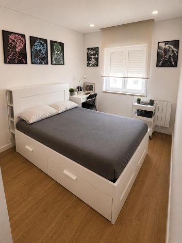 a bedroom with a large bed and a desk at Waves beach house in Viana do Castelo