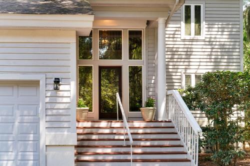 a white house with stairs and a door at 2873 Hidden Oak Drive in Seabrook Island