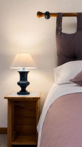 Eine Lampe auf einem Nachttisch neben einem Bett in der Unterkunft Loft Bonbon in Cinisi