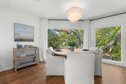 a dining room with a table and chairs and a chandelier at 774 Spinnaker Beach House in Seabrook Island