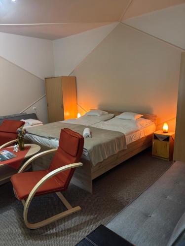 a bedroom with a bed and a chair and a table at A-BB-LAK in Hajdúszoboszló
