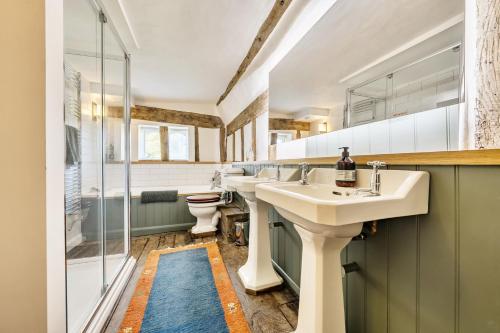a bathroom with two sinks and a shower at Cutbush Farmhouse in Norwich