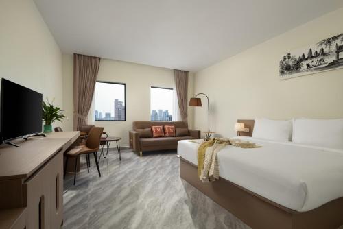 a hotel room with a bed and a couch at Amana Hotel Phnom Penh in Phnom Penh