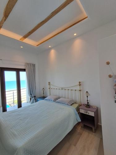 a bedroom with a bed with a view of the ocean at Aegean Infinite View-Beachfront Suite Pelion in Chorefto