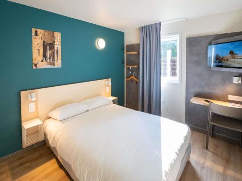 a bedroom with a white bed and a desk at ibis budget Orange Centre in Orange