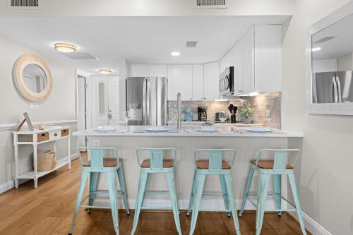 a kitchen with three blue stools at a counter at 2943 Atrium Villa in Seabrook Island