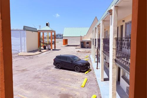 a car parked in a parking lot next to a building at Del Rio Inn TX By Hotel O in Del Rio