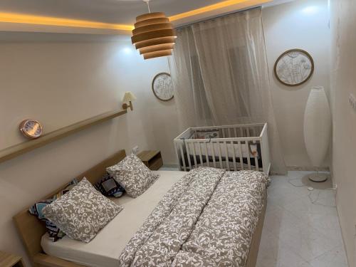 a small bedroom with a crib and two clocks at Escapade urbaine moderne in Sétif