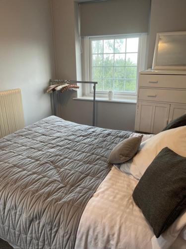 a bed in a bedroom with a window at Stunning coastal cottage in Worle