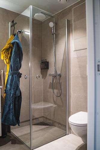 a shower with a glass door in a bathroom at Modern apartment with balcony and view in Trondheim