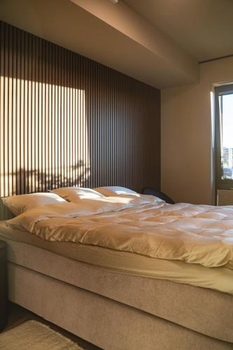 a large bed in a bedroom with a window at Modern apartment with balcony and view in Trondheim