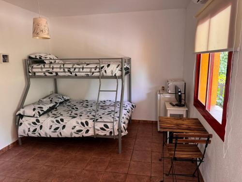 a room with two bunk beds and a table at Camping Riba-roja in Riba-roja d'Ebre