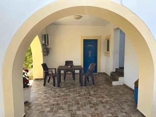 a dining room with an archway with a table and chairs at Green Parrot Apartments in Frátsia