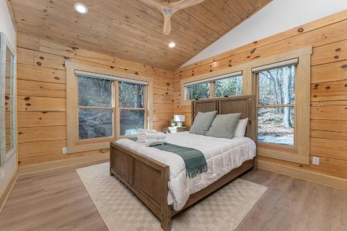 a bedroom with a large bed in a room with wooden walls at Luxury Log Cabin with lake view in Black Mountain