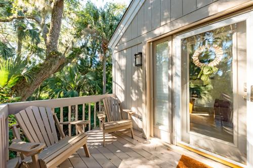 two chairs sitting on the porch of a house at 804 Treeloft Cottage in Seabrook Island