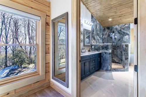 a bathroom with a shower and a sink and a mirror at Luxury Log Cabin with lake view in Black Mountain