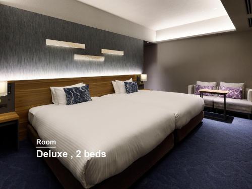 a hotel room with a large bed and a couch at Mitsui Garden Hotel Gotanda - Tokyo in Tokyo