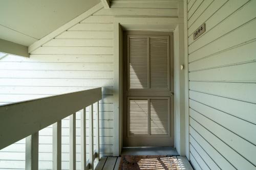 a hallway with a door and a stair case at 1644 Courtside Villa in Seabrook Island