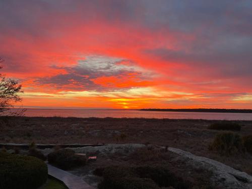 a sunset over a body of water with the sun setting at 1340 Pelican Watch Villa in Seabrook Island