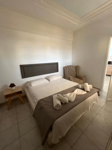 a bedroom with a large bed with towels on it at Leon Lux Apartment in Perivolos